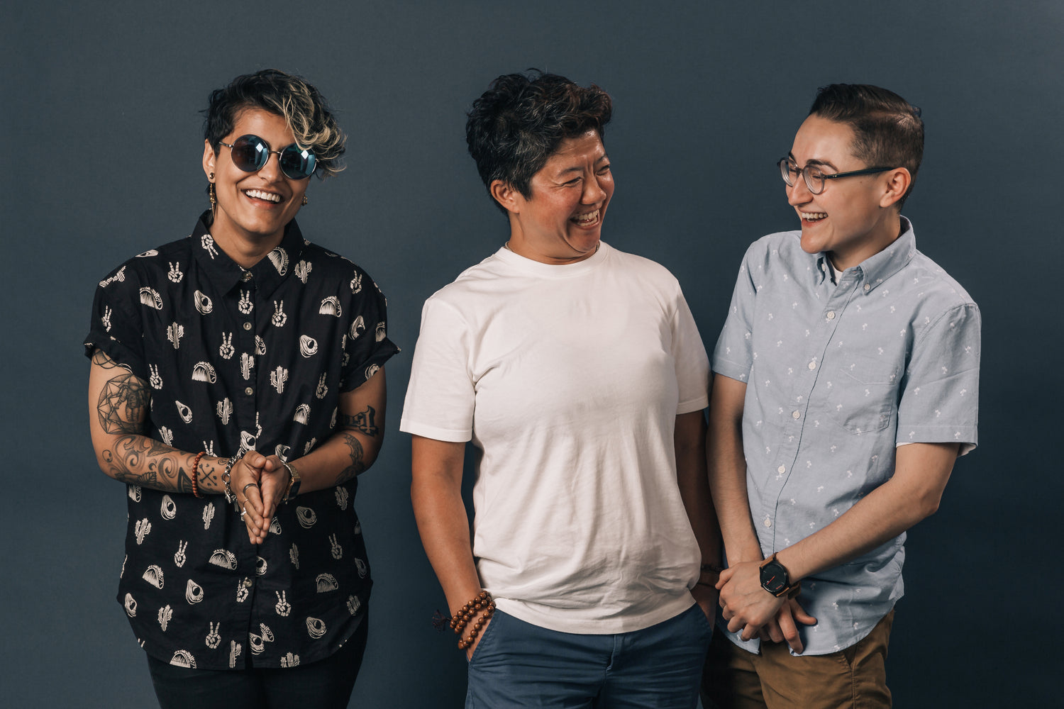 Three friends laughing together in a casual lifestyle photo.